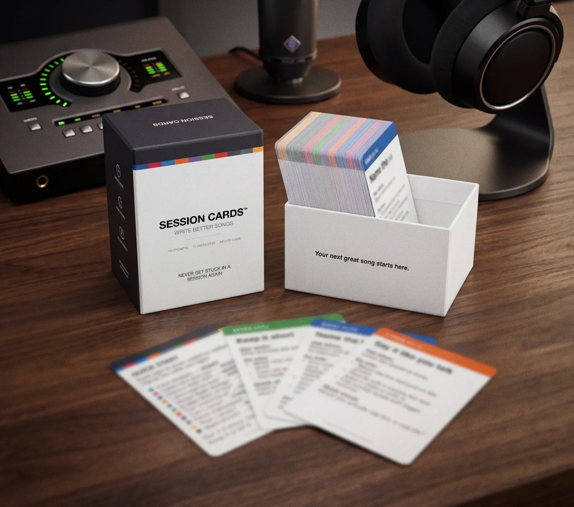 Session Cards Edition 001 on a studio desk, box and cards spread out with headphones and audio interface. 144 platinum-tested moves for songwriters and producers.